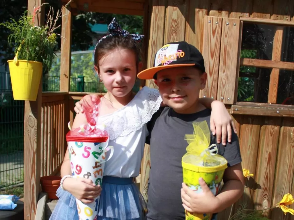 Schulkinder tragen eine bunte Schultüte